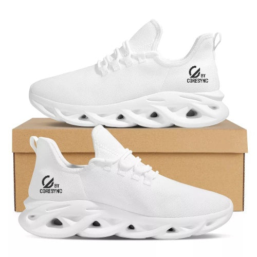 All-white breathable knit sports shoes with sculpted sole design and "by CoreSync" logo on heel, displayed on a cardboard shoebox.
